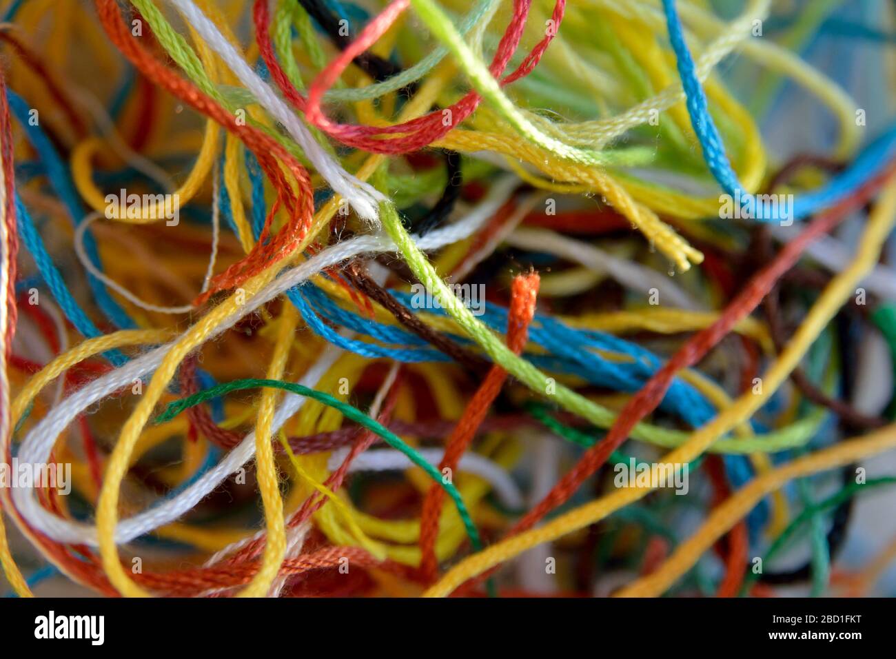 A tangle of multi coloured offcuts of embroidery thread, background texture photo Stock Photo