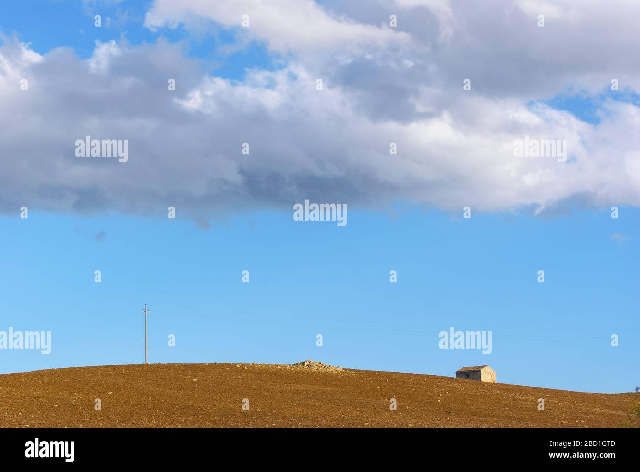 plowed field and rural house minimalist landscape of Sicily Stock Photo