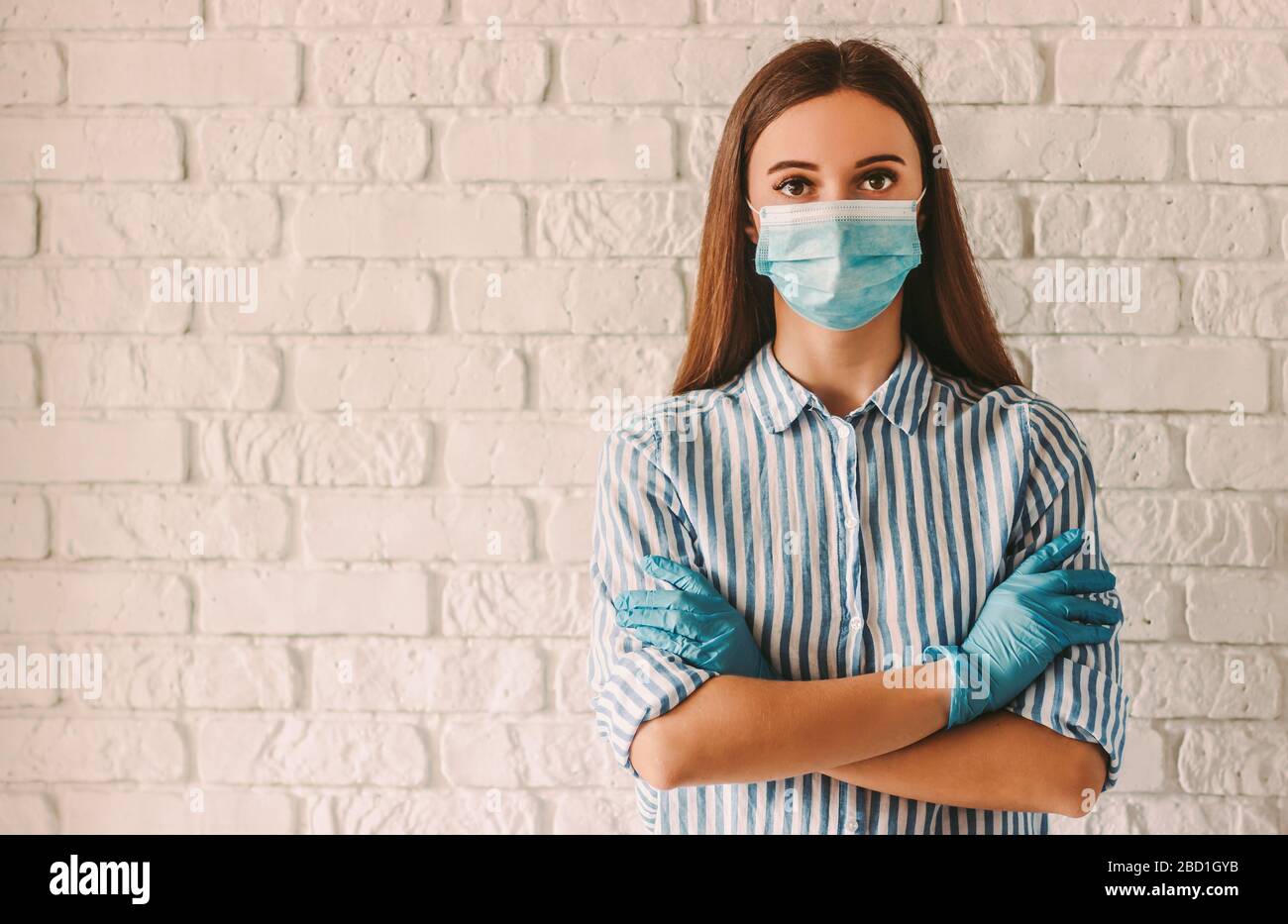 Young woman wearing protective mask on face and medical gloves keeping ...