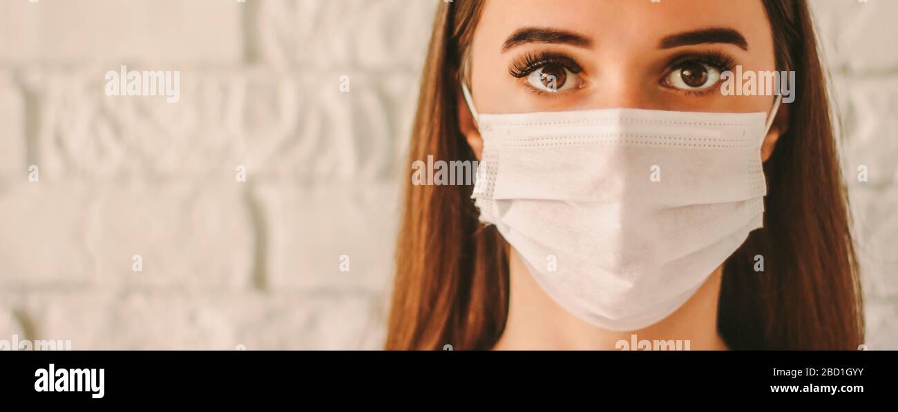 Banner confident female doctor surgeon in protective mask on face in hospital. Young sick woman in medical face mask. Infected girl wears face mask. C Stock Photo