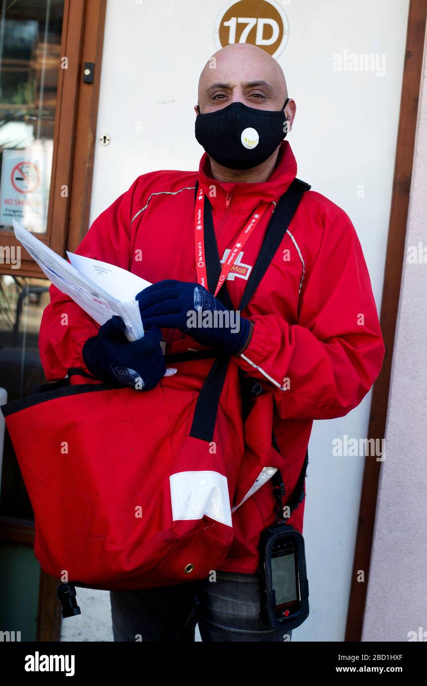 Hackney, London, England, UK. Corona Virus (Covid-19) pandemic. A Royal Mail postman wearing a protective mask;delivers the letter from Boris Johnson Stock Photo