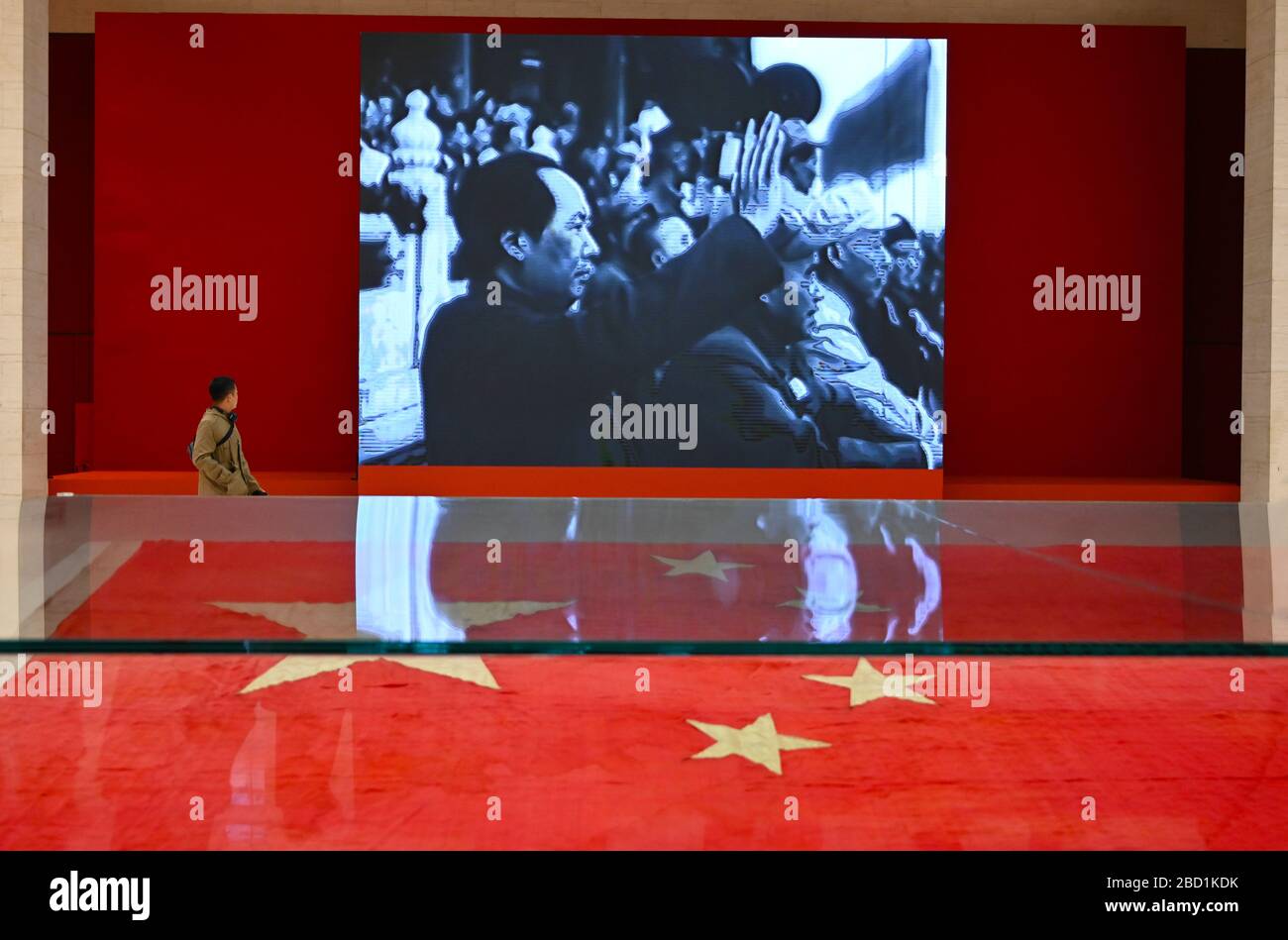 Museum visitor walking past party political slideshow in the National Museum of China, Beijing, China, Asia Stock Photo