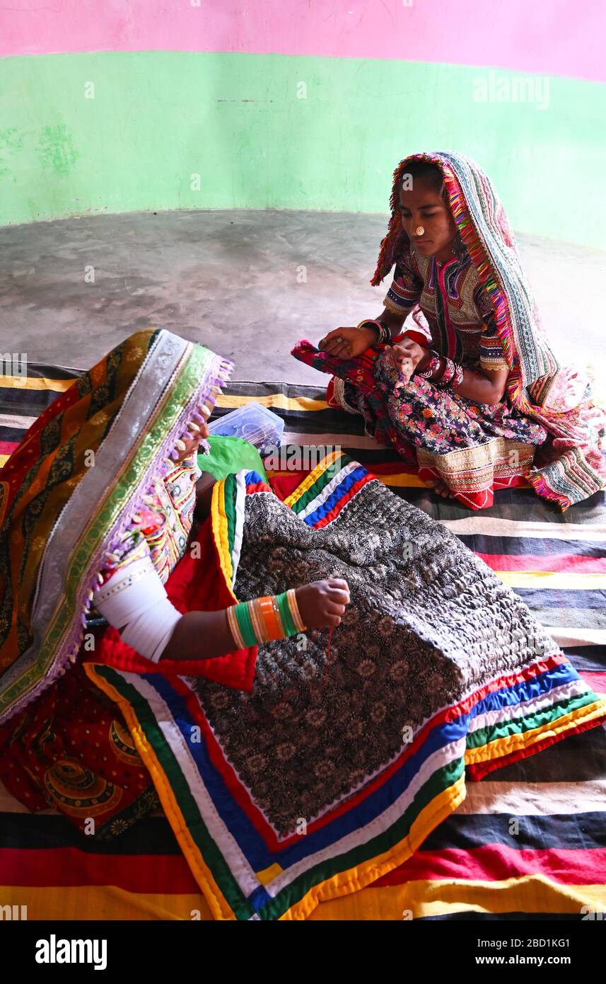 Women embroidering traditional tribal quilts in their bhunga (circular village mud house), Bhirindiara, Kutch, Gujarat, India, Asia Stock Photo