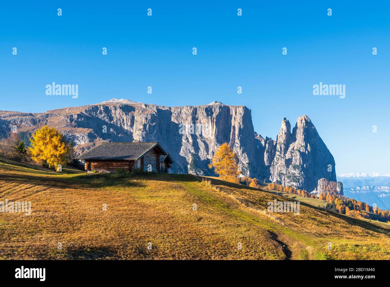 Traditional huts at Alpe di Siusi (Seiser Alm) in autumn with Sciliar peaks in background, Dolomites, South Tyrol, Italy, Europe Stock Photo