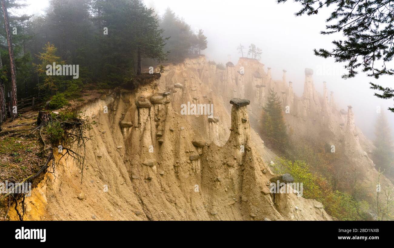 Earth Pyramids and woods in the autumn mist, Perca (Percha), province of Bolzano, South Tyrol, Italy, Europe Stock Photo