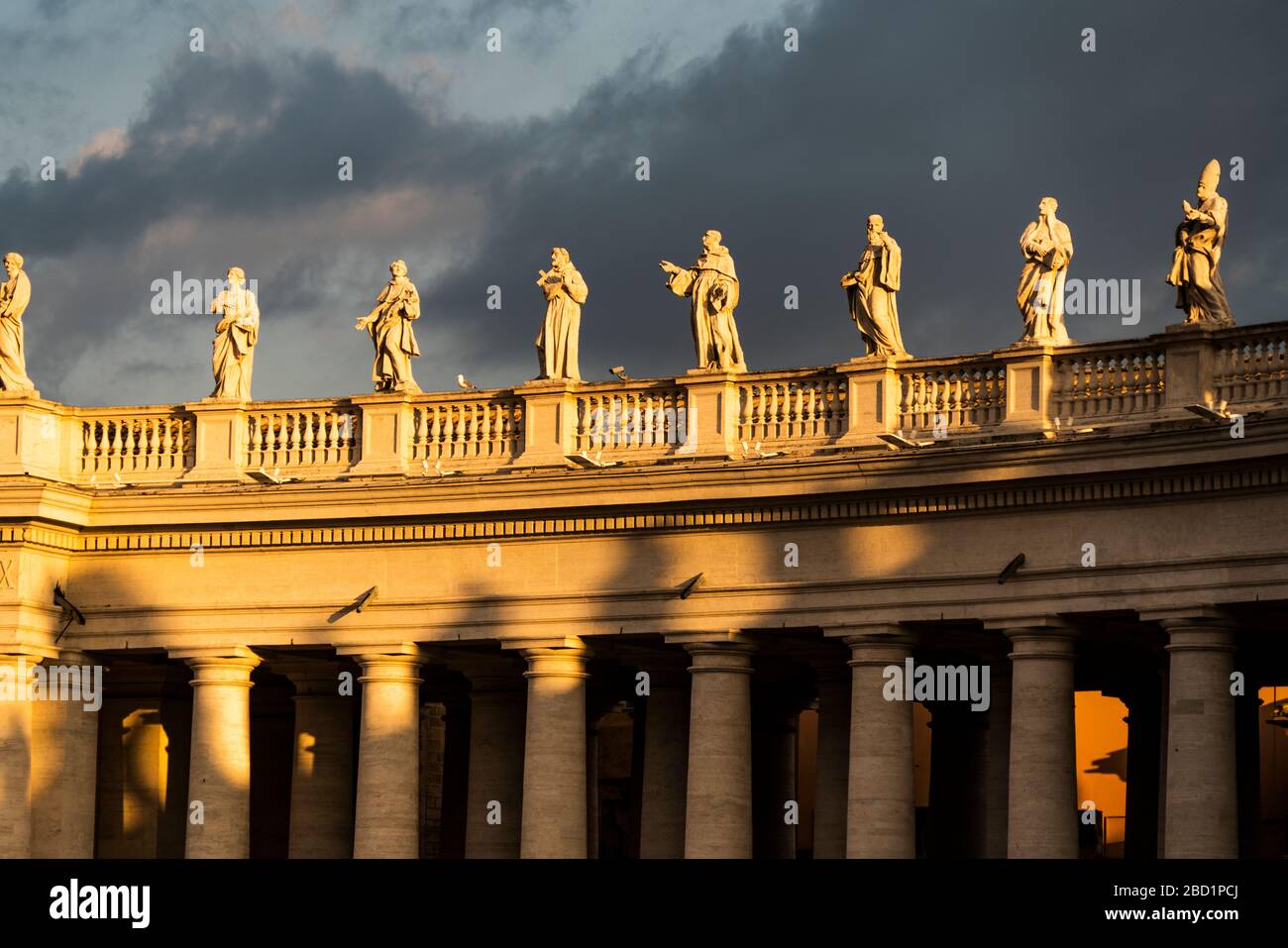 Statues of St. Peter's Square colonnade lit by sunrise, Vatican City ...