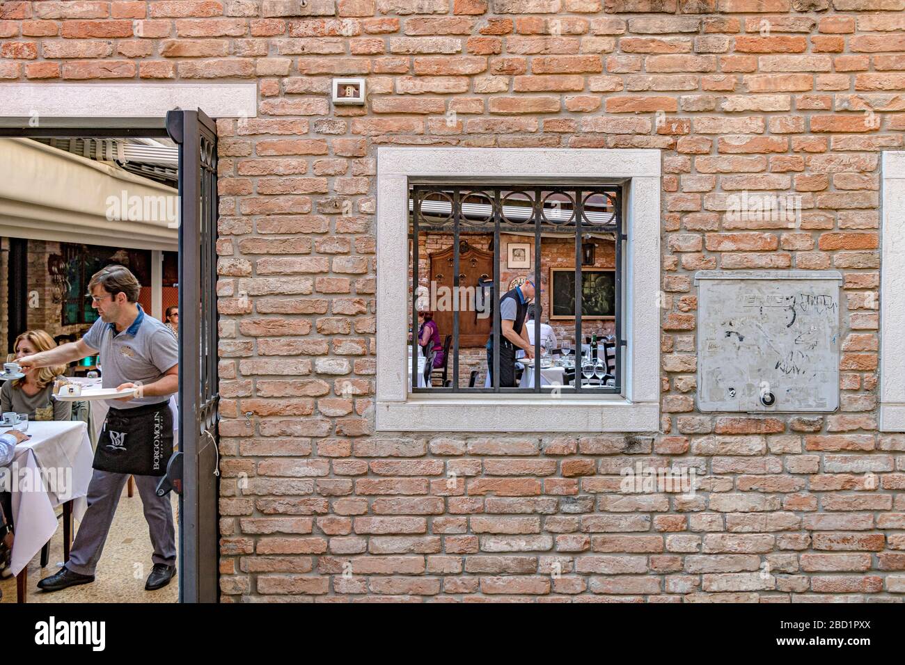 Waiters serving tables at  Al Casin Dei Nobili Ristorante an Italian restaurant  in the Dorsoduro district of Venice ,Italy Stock Photo