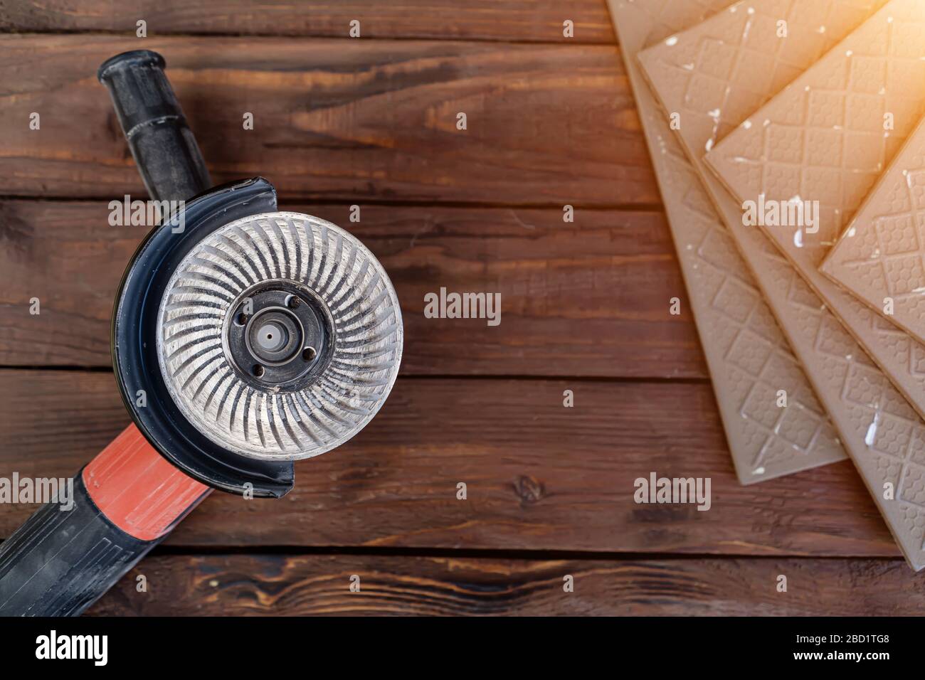 angle grinder and ceramic tile on a wooden background Stock Photo