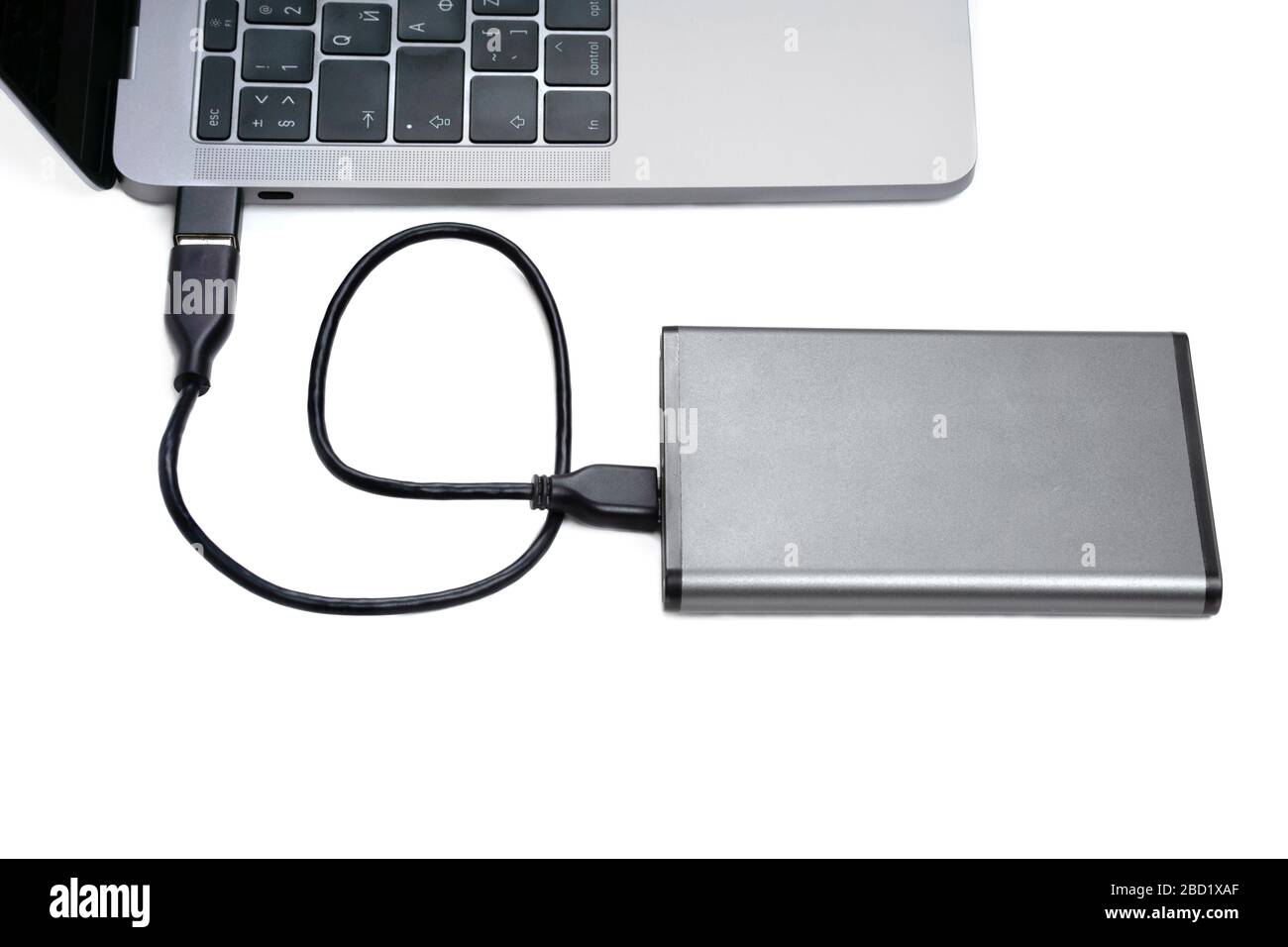 Dark grey portable hard disk drive connected to a laptop computer via  adaptor isolated on white Stock Photo - Alamy