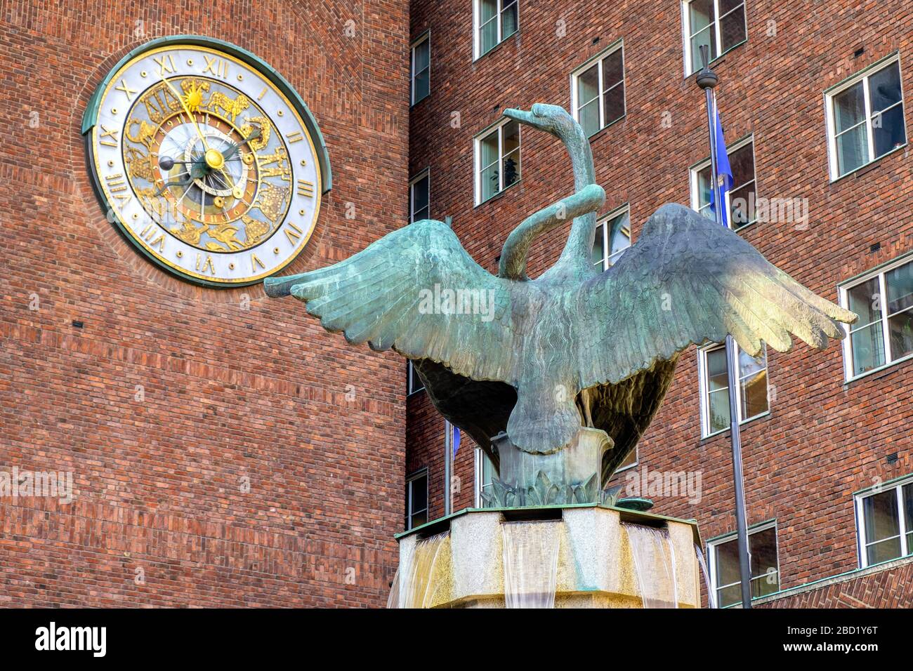 Oslo, Ostlandet / Norway - 2019/08/30: Swan fountain sculpture by Dyre Vaa in front of City Hall historic building - Radhuset - with astronomic clock Stock Photo