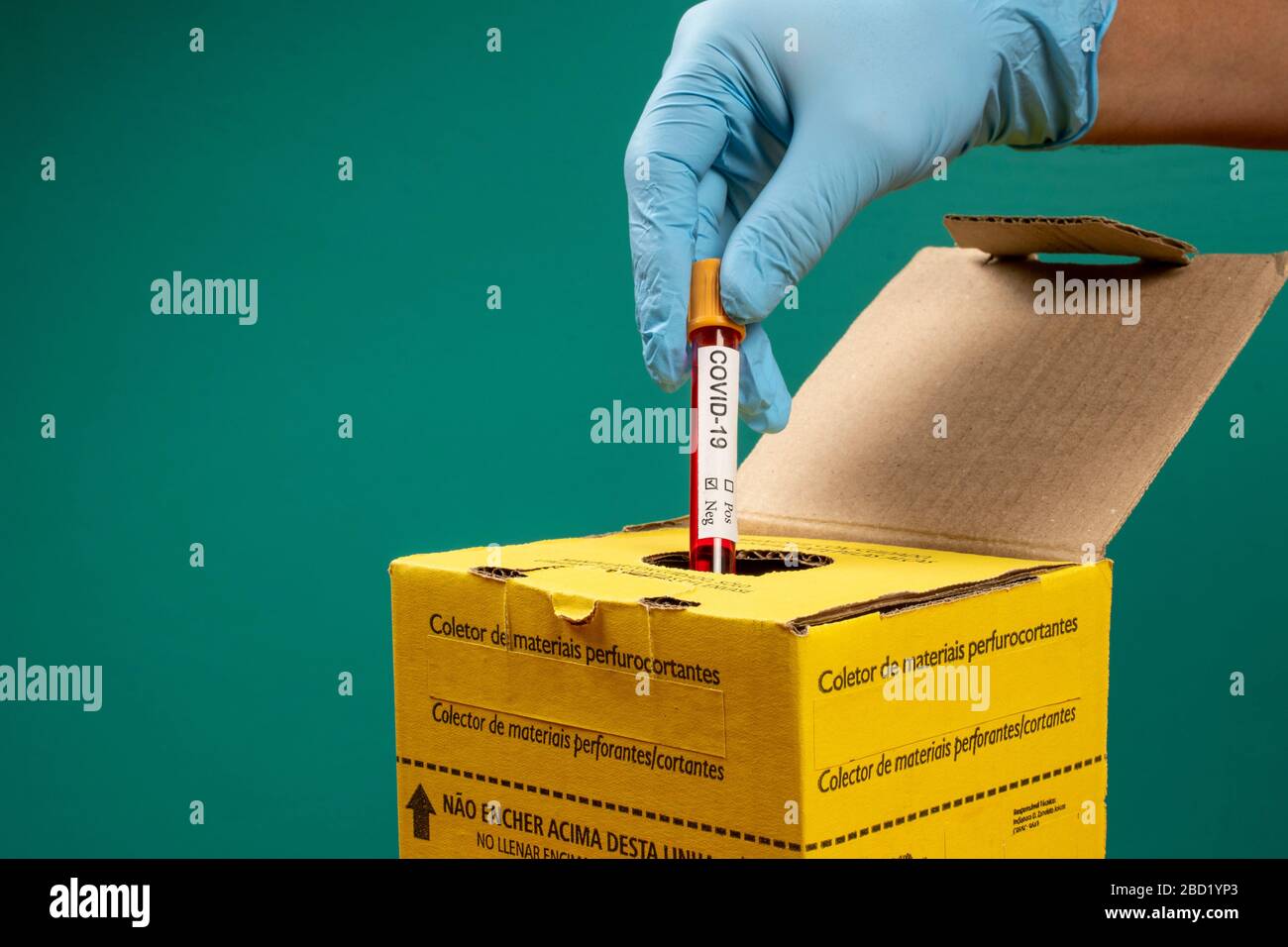 doctor throwing out vacuum tube in an infectious waste disposal box
