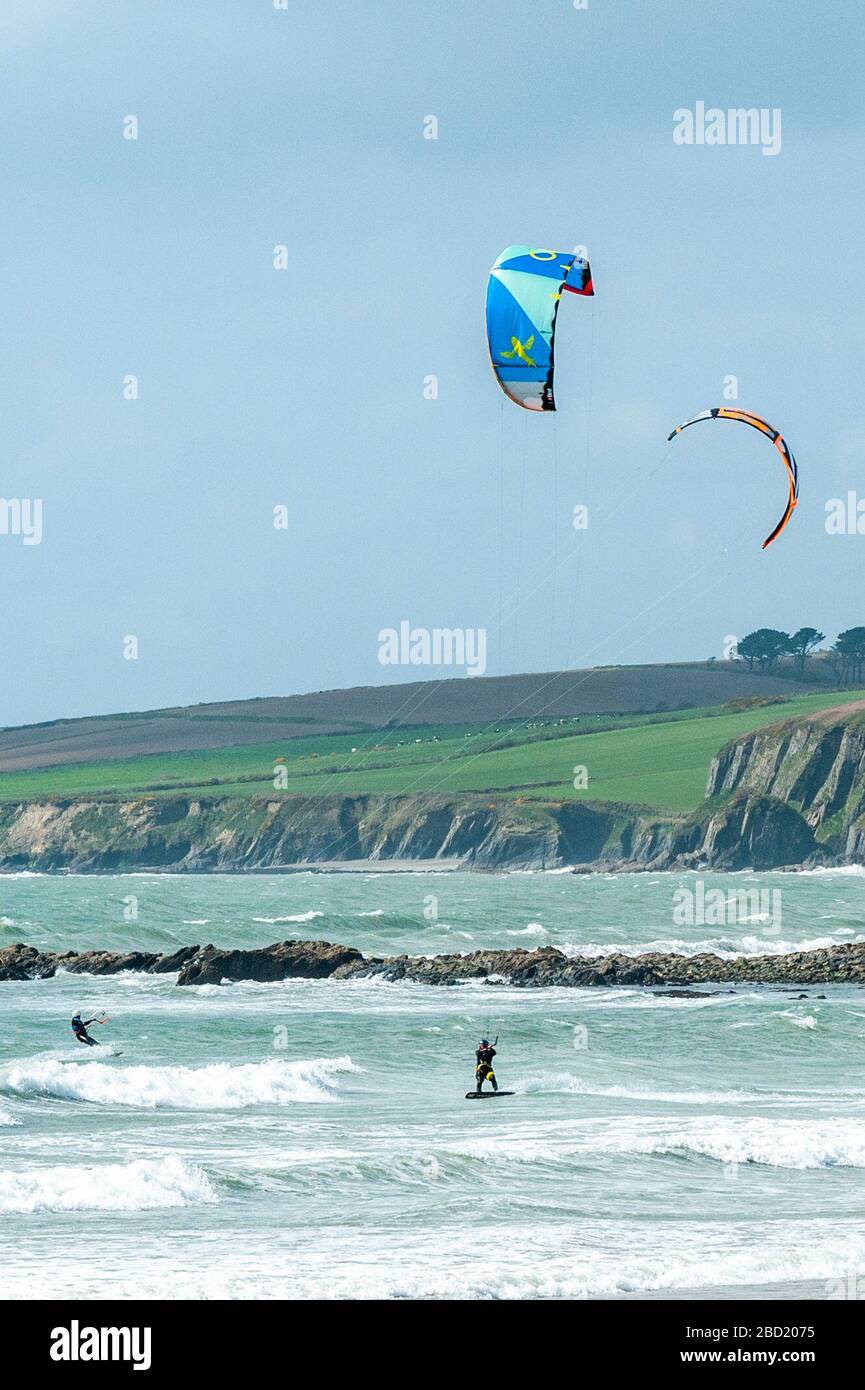 Garrettstown, West Cork, Ireland. 6th Apr, 2020. Two kite surfers enjoy the strong winds and big waves at Garrettstown Beach whilst observing the Government's social distancing guidelines during the Covid-19 pandemic. Credit: Andy Gibson/Alamy Live News Stock Photo