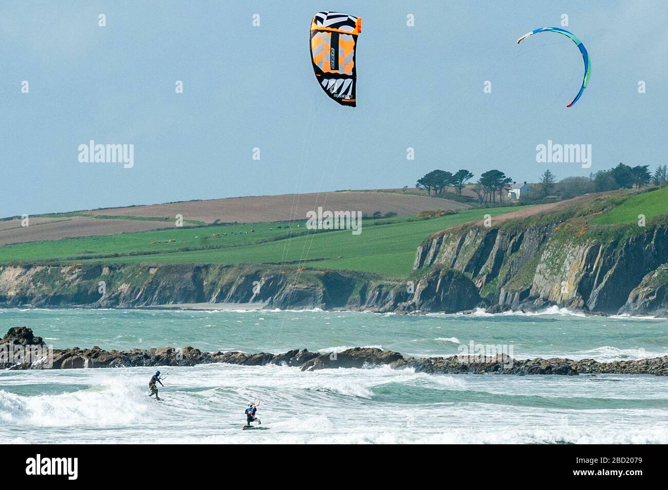 Garrettstown, West Cork, Ireland. 6th Apr, 2020. Two kite surfers enjoy the strong winds and big waves at Garrettstown Beach whilst observing the Government's social distancing guidelines during the Covid-19 pandemic. Credit: Andy Gibson/Alamy Live News Stock Photo