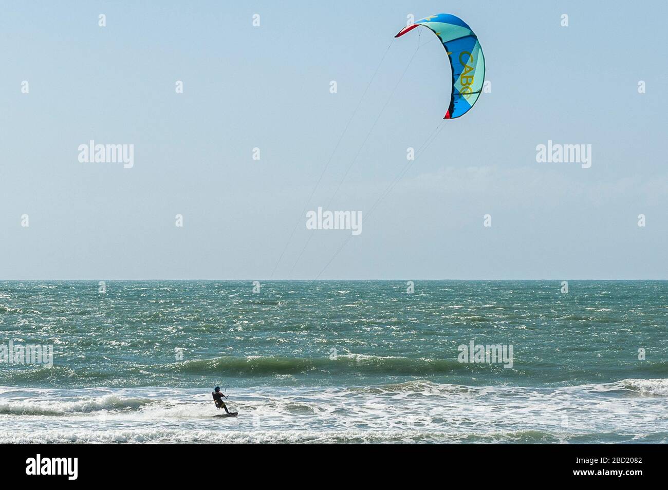 Garrettstown, West Cork, Ireland. 6th Apr, 2020. A kite surfer takes advantage of the strong winds and big waves at Garrettstown Beach whilst observing the Government's social distancing guidelines during the Covid-19 pandemic. Credit: Andy Gibson/Alamy Live News Stock Photo