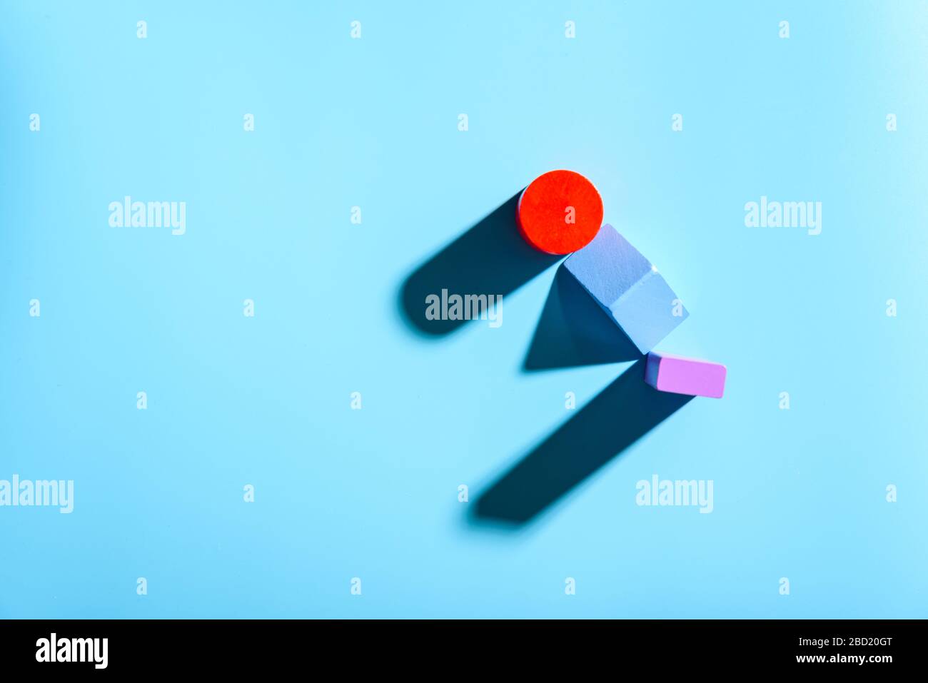 Blue background with red geometric figures casting shadows in a simple composition. Stock Photo