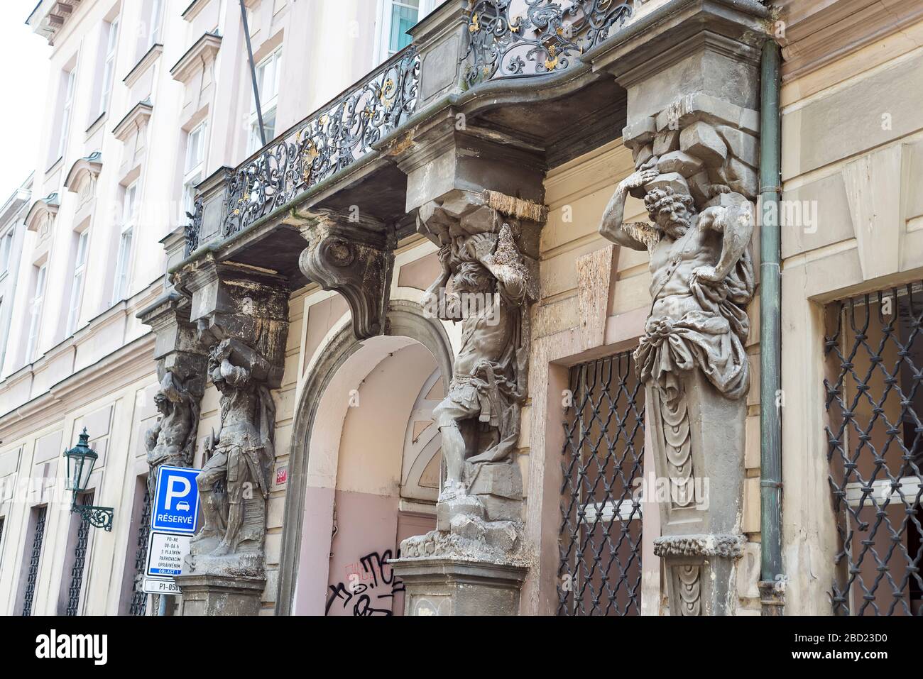 Prague, Czech Republic - 17.07.2018. Architectural details of historic facade with stone atlantes holding a balcony of old-fashioned building in Pragu Stock Photo