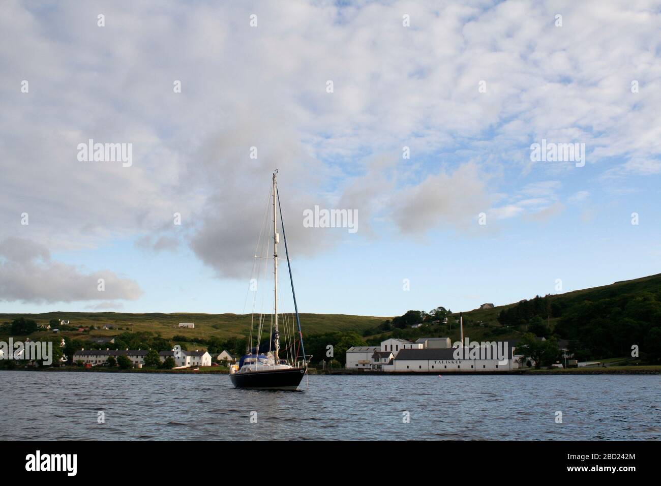 Sailing yacht anchored off Talisker distillery, Carbost, Loch Harport, Isle of Skye, Hebrides, Scotland Stock Photo