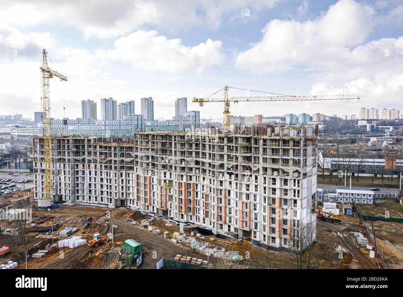 city construction site with yellow tower cranes and machinery. aerial top view of residential construction area. Stock Photo