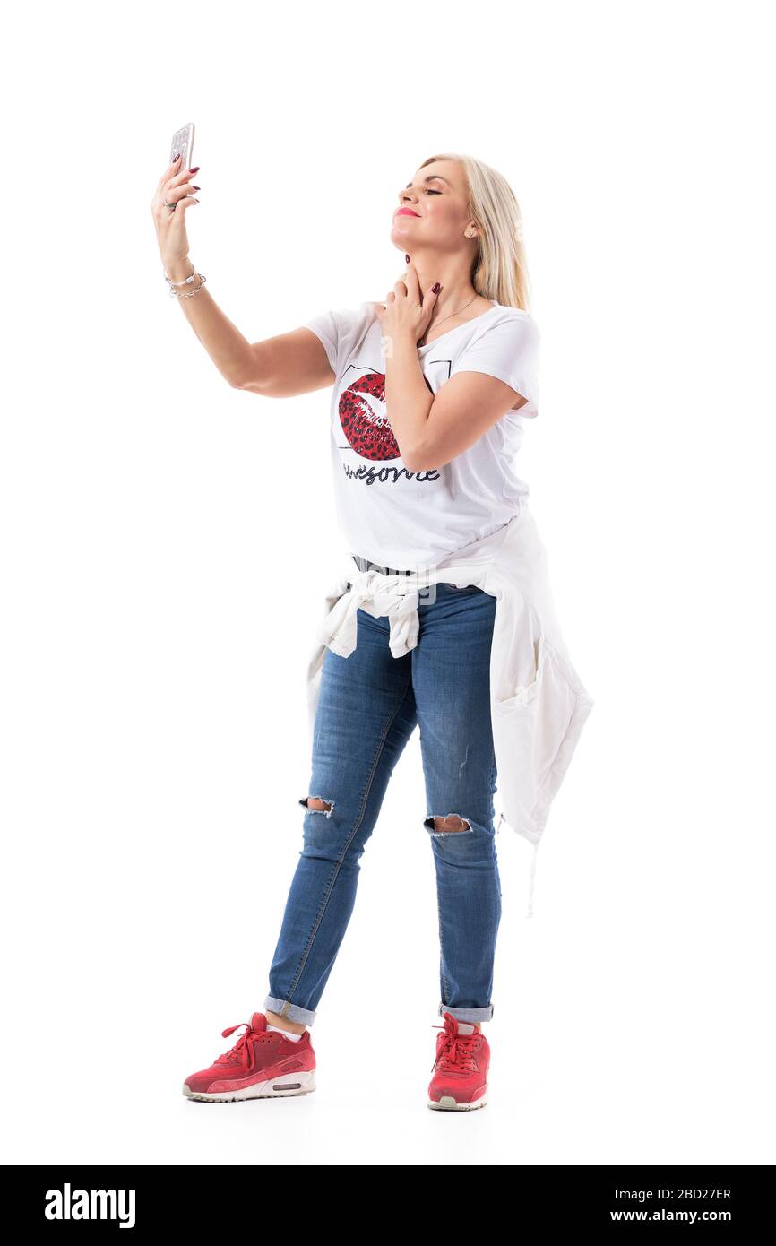 Confident modern middle age woman in casual clothes taking selfies with