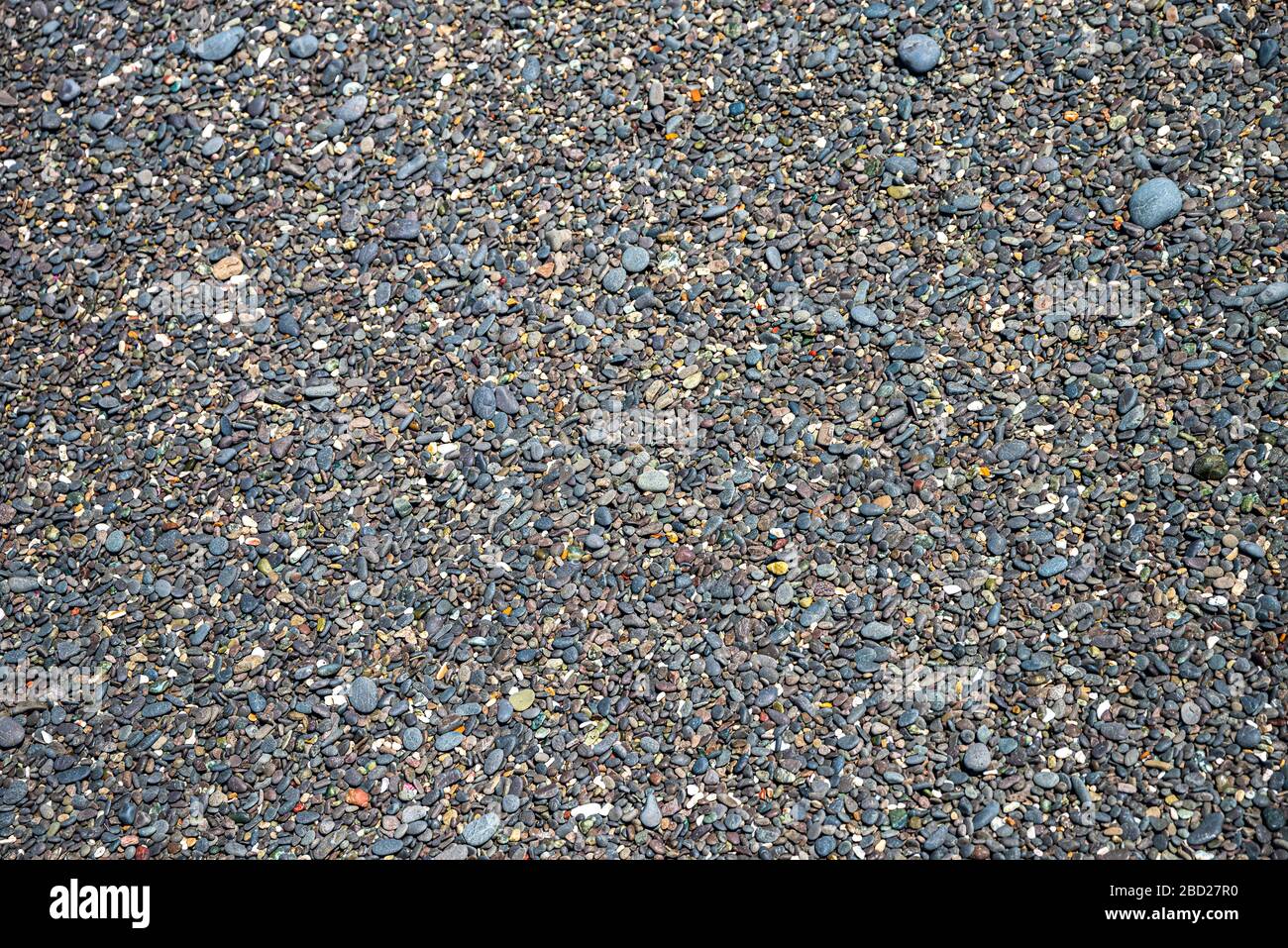 Black pebbles on a stone beach Stock Photo