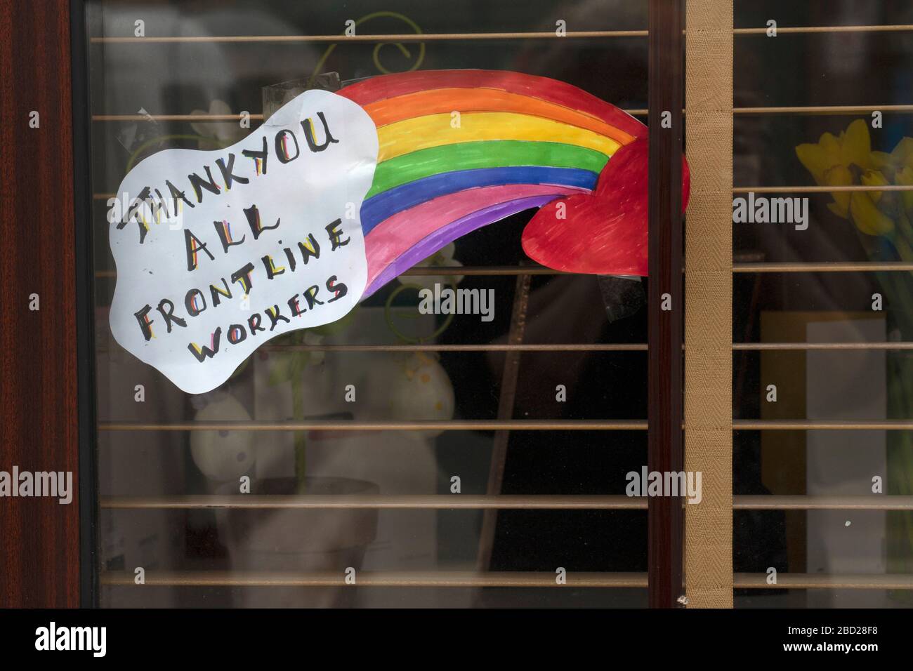 Childs drawing of a rainbow with thank you messages for NHS staff and key workers in a window of a house during government imposed lockdown in Wales Stock Photo