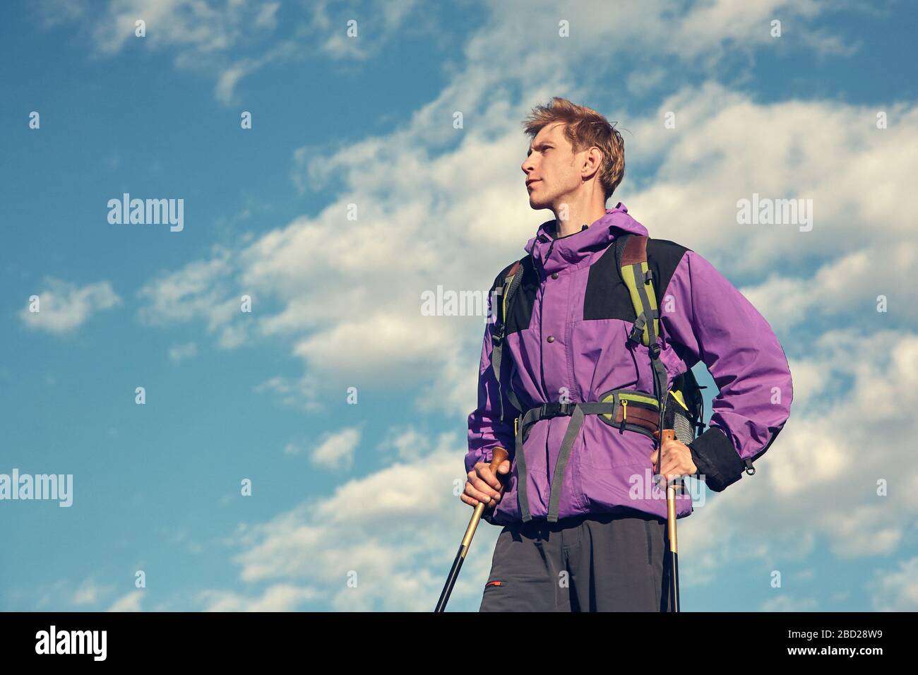 climber on trail in the mountains. a man with a backpack in a hike. Stock Photo