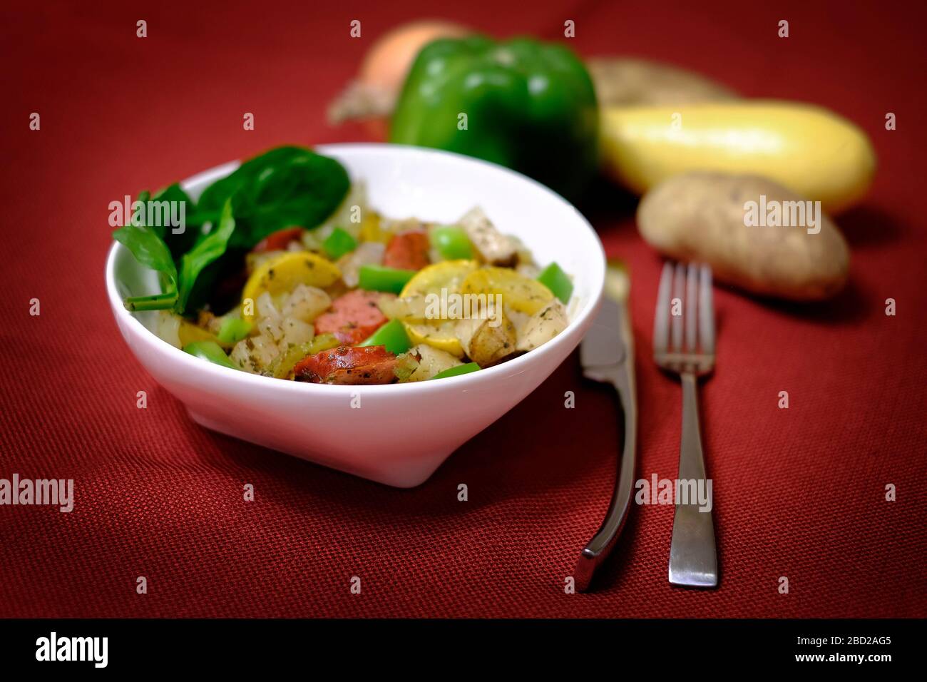 Sausage dinner in a bowl silverware hearty meal peppers and potatos Stock Photo
