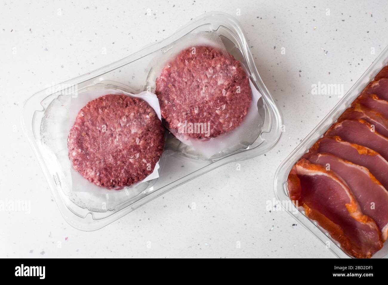 Different types of meat packaged in plastic on wooden table Stock Photo