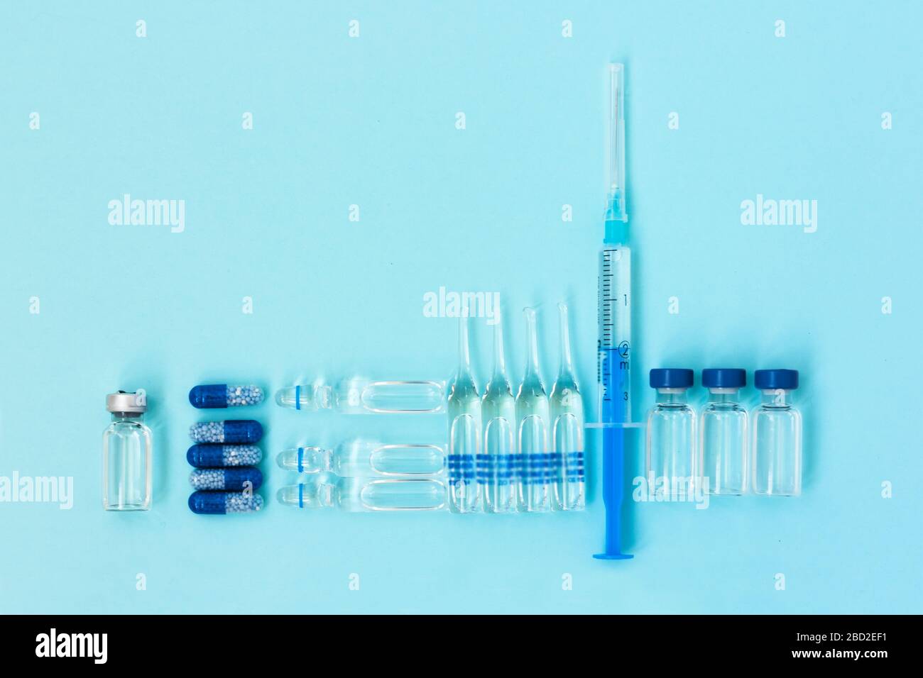 Thermometer, pills, injection ampoules, syringe for vaccination on a blue background, healthcare coronavirus, cancer, painand treatment, pharmaceutica Stock Photo