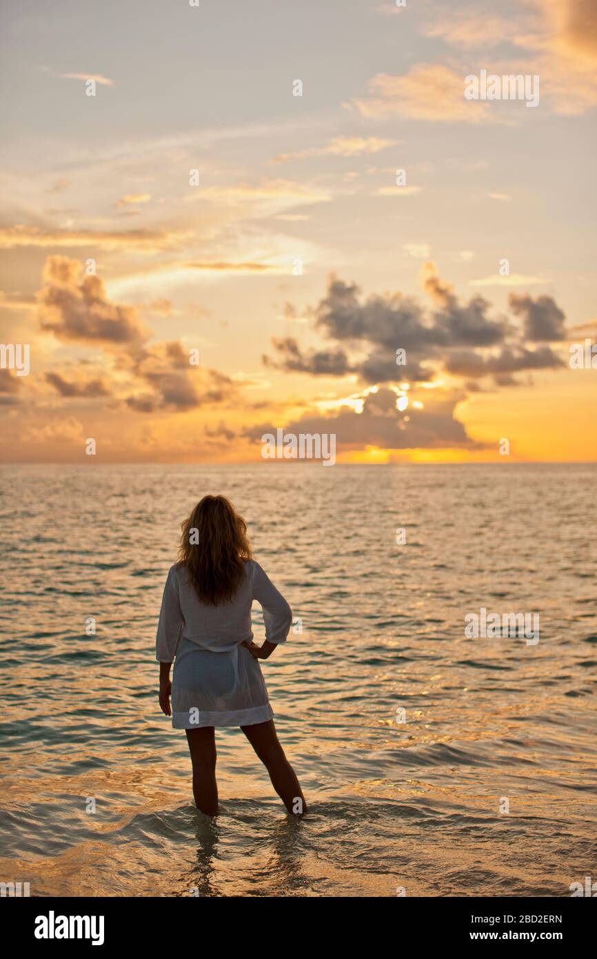 Woman watching sunset beach arms hi-res stock photography and images ...