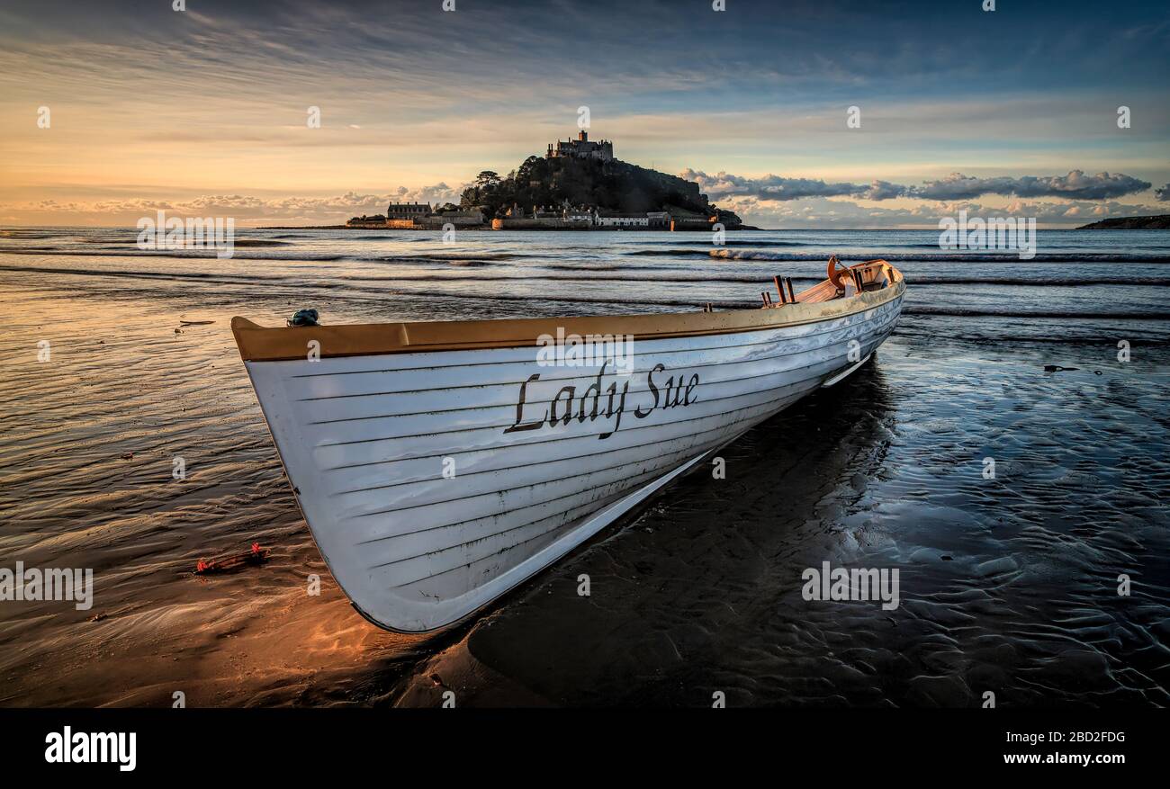 Pilot Gig on Mounts Bay Beach at sunset. St Michaels Mount behind Stock Photo