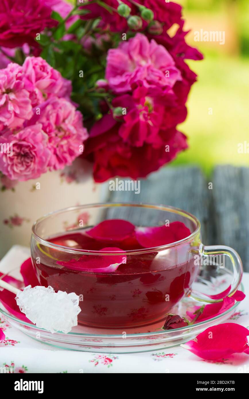 Rose tea with fresh roses on wooden background Stock Photo - Alamy