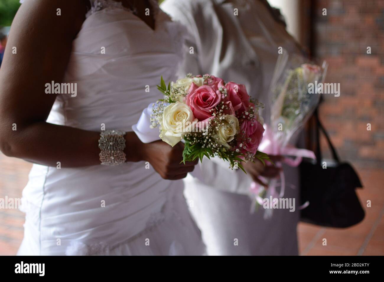 Bride carrying bouquet of flowers as she enters church Stock Photo Alamy