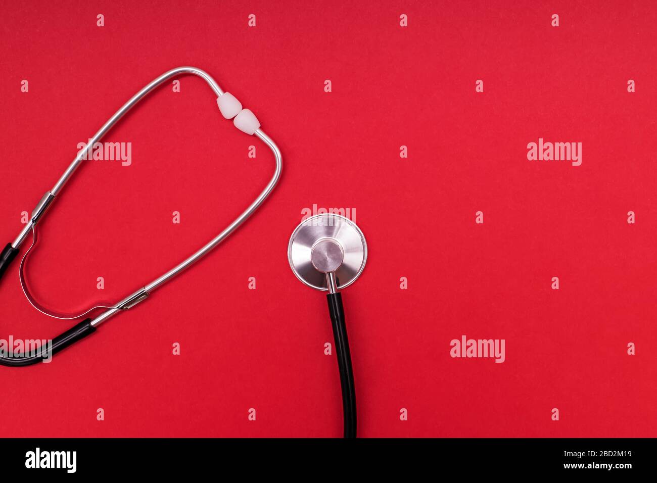 Stethoscope or phonendoscope isolated on red background. Stock Photo