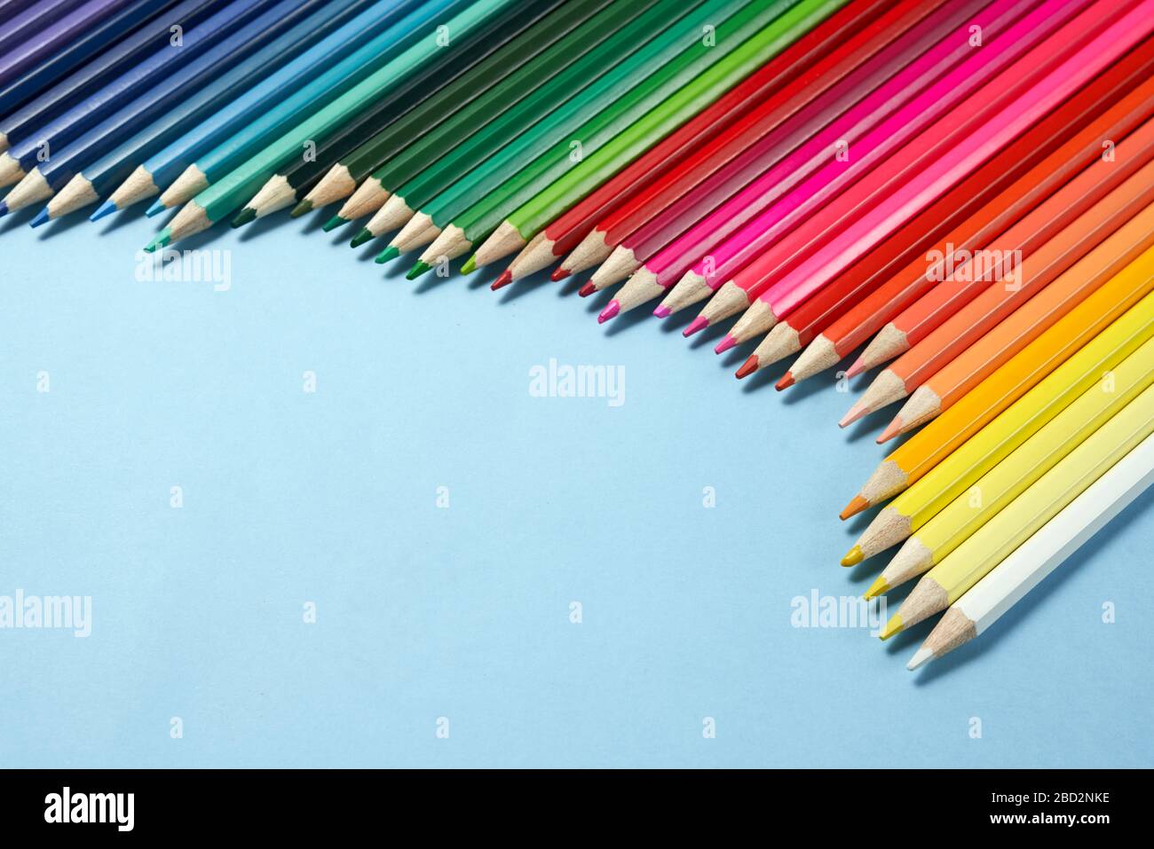 Assortment of coloured pencils on blue background.school equipment Stock Photo