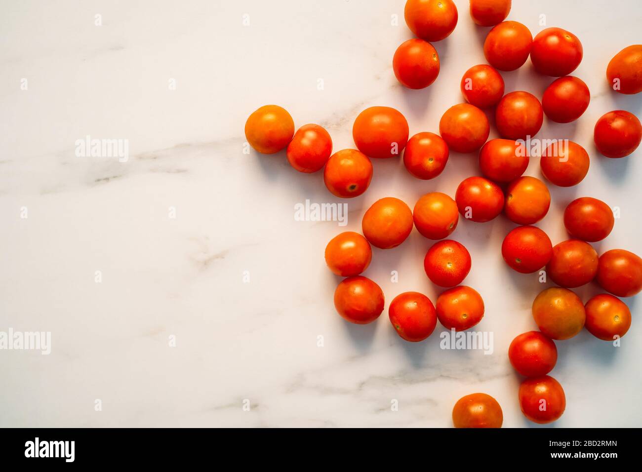 Set of fresh whole cherry tomatoes on white stone background. Top view ...