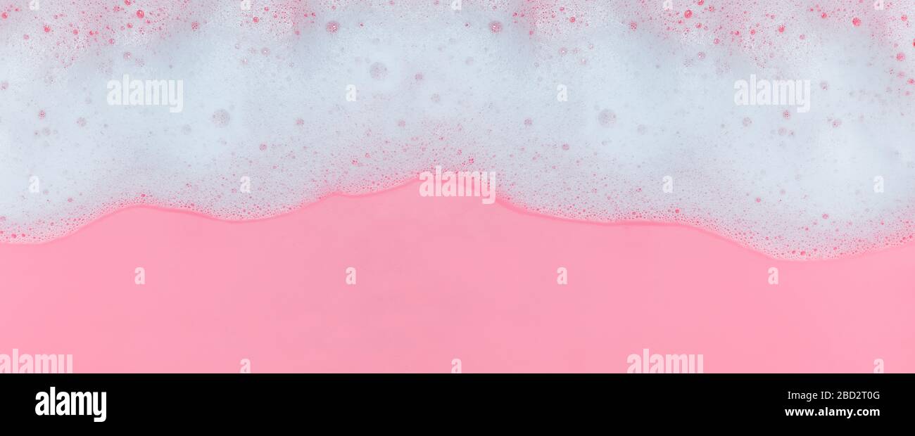 White soap foam with bubbles on pink background Stock Photo