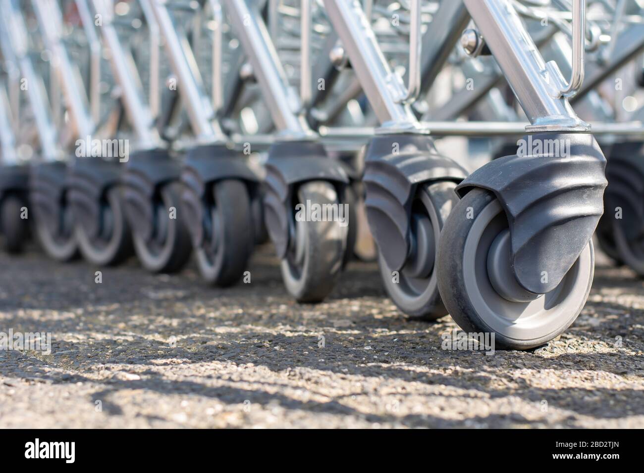 Modern supermarket shopping cart wheels in a row. Many rubber wheels of