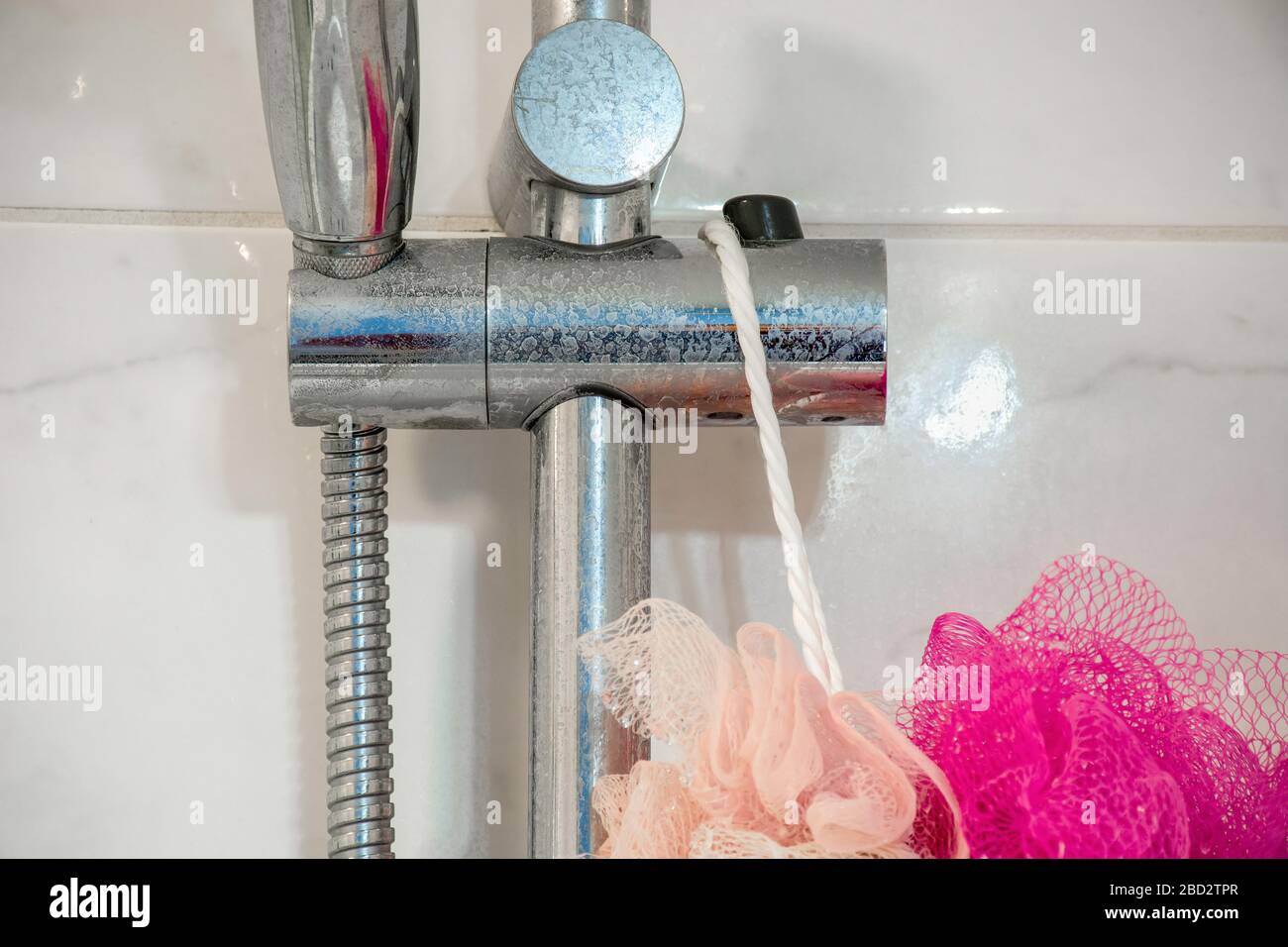 Dirty chrome shower rod with limescale that should be cleaned.  Calcified shower due to hard water. Calcium mineral buildup. Stock Photo