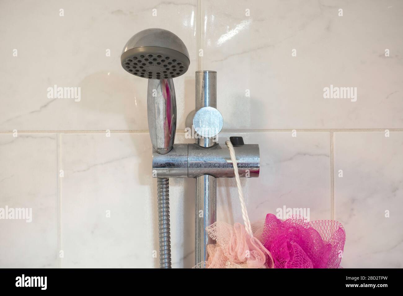 Dirty chrome shower rod with limescale that should be cleaned.  Calcified shower due to hard water. Calcium mineral buildup. Stock Photo