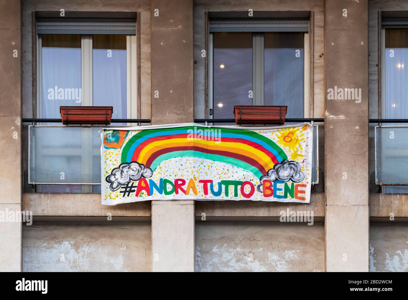 Rome, Italy - April 5, 2020: During the emergency for Covid-19 (coronavirus), the Italians locked up in the quarantined house display the rainbow flag on the windows of the buildings, with the words 'everything will be fine'. Stock Photo