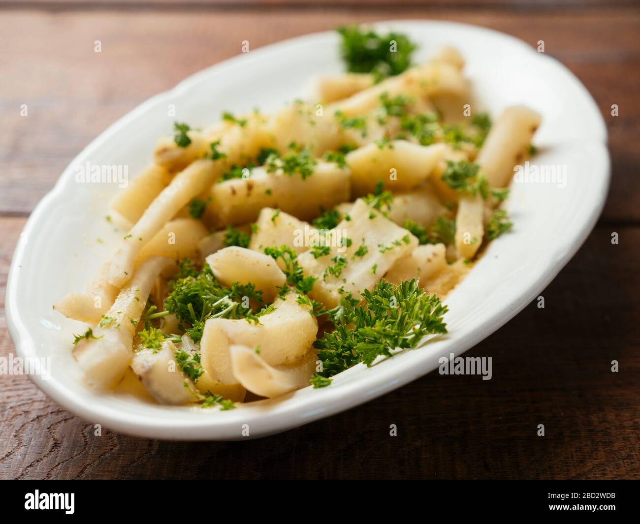 Common salsify with a garlicy lemon sauce as side-dish. Stock Photo