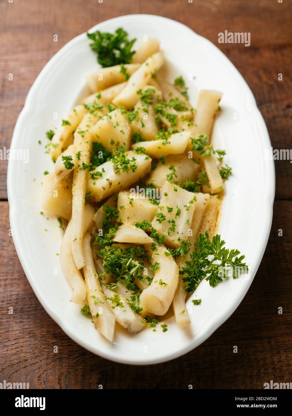 Common salsify with a garlicy lemon sauce as side-dish. Stock Photo