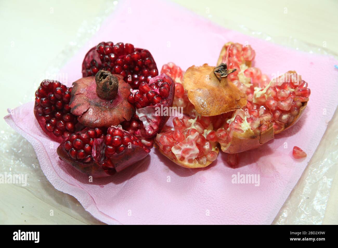 With clipping path. Full depth of field. Ripe pomegranate fruit on white isolated background. Juicy bright shiny pomegranate kernels isolated on white Stock Photo