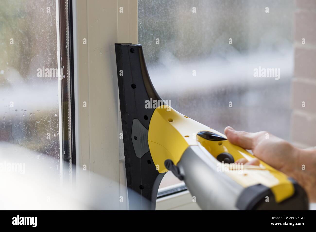 Cleaning windows with electric vacuum cleaner. Spring house cleaning