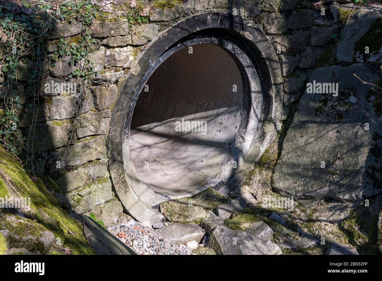 Sewer with large opening and stone wall Stock Photo