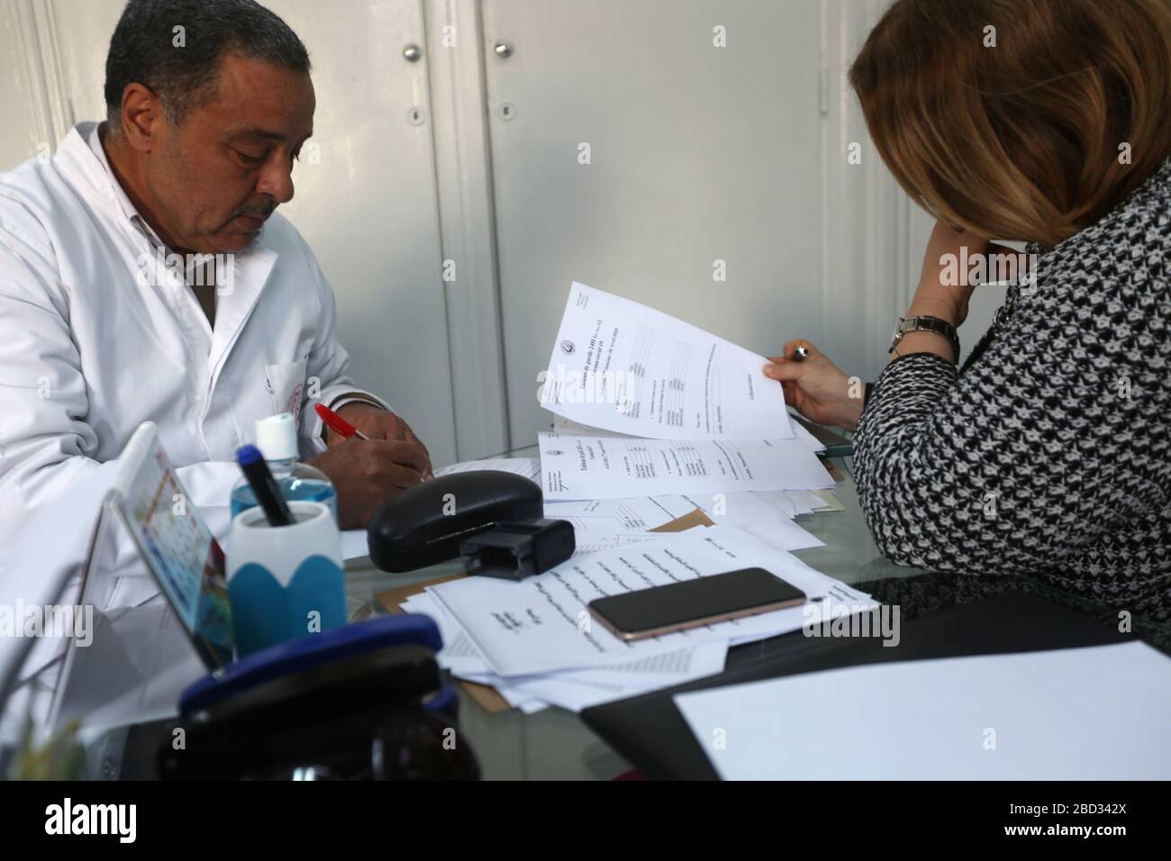 Tunis, Tunisia. 31st Mar, 2020. (L) CoViD-19 unity's supervisor and (R) Administrator director during the agents planification timing in the unity at the administration of the Habib Thameur Hospital on March 31, 2020 in Tunis, Tunisia. The Habib Thameur Hospital in Tunis, Tunisia has created a path for patients who need testing for the Covid-19 coronavirus. Daily, the Tunisian Ministry of Health performs around 700 Coronavirus tests and is working to reach 1000 tests soon. (Photo by Mohamed Krit/ Credit: Sipa USA/Alamy Live News Stock Photo