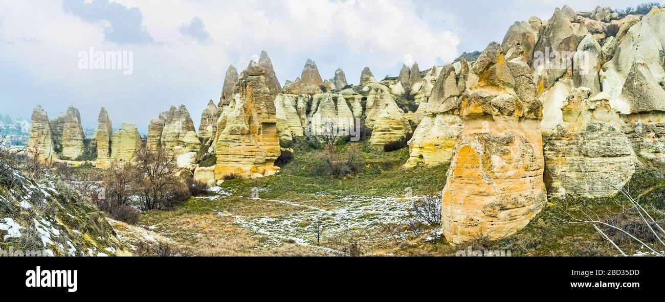 The hundreds of cone-shaped tuff fairy chimney rock formations, located on the hilly slope in Cappadocia, Turkey Stock Photo