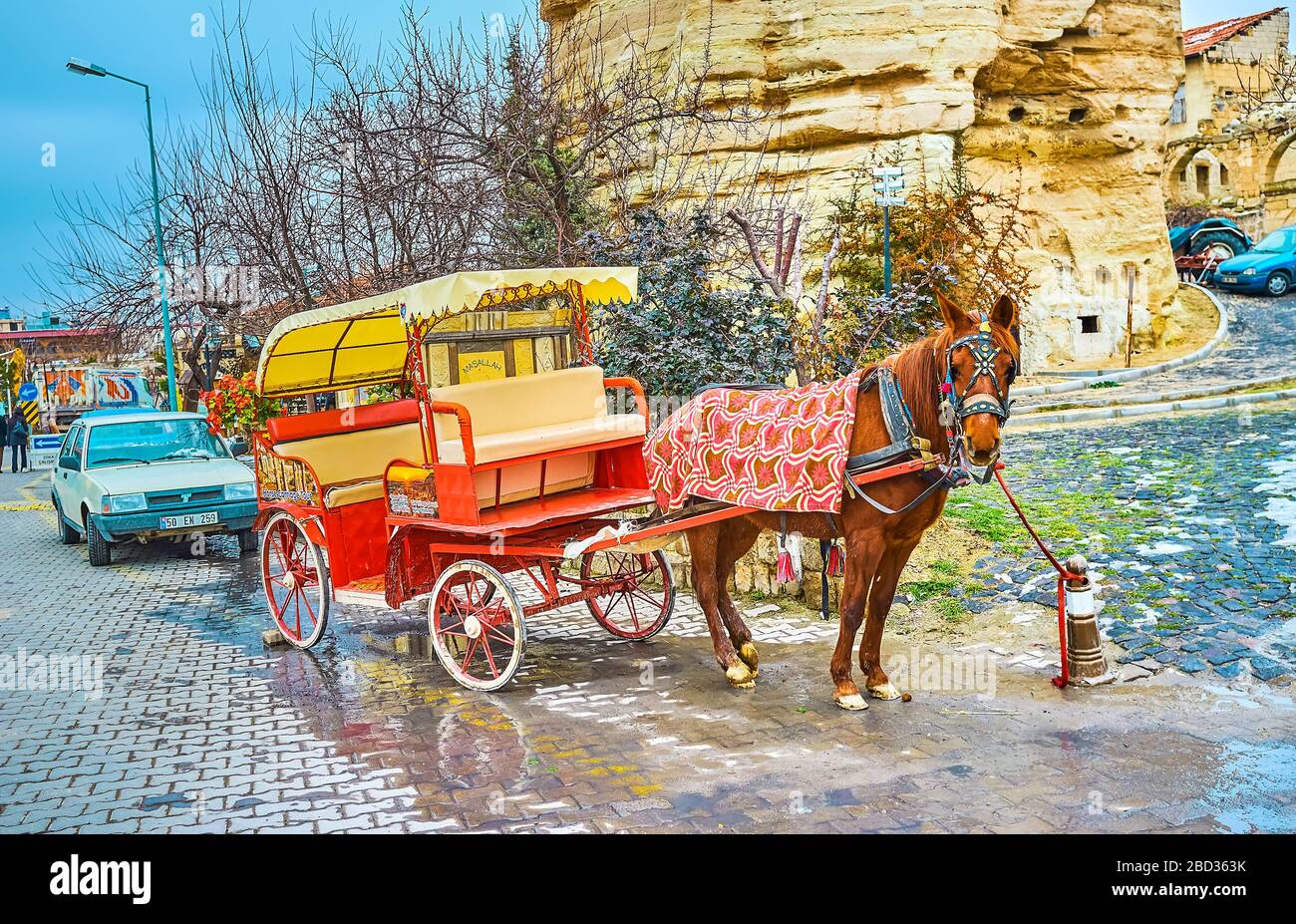 GOREME, TURKEY - JANUARY 17, 2015: The horse-drawn carriage attracts the tourists to ride around the landmarks of the town and its surroundings, on Ja Stock Photo