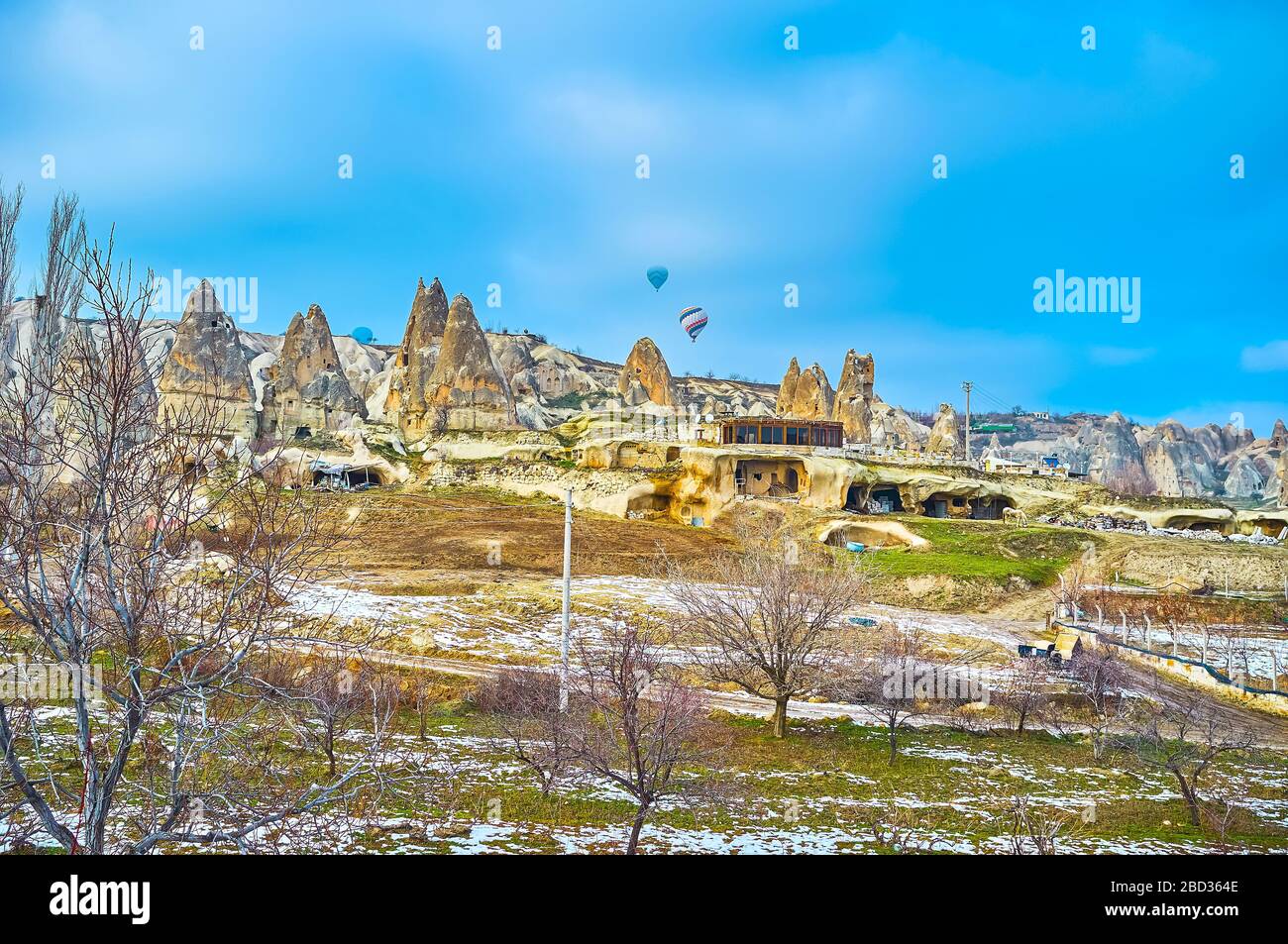 Watch the rocky landscape of Goreme with fairy chimney formations and hot air balloons in the sky, Cappadocia, Turkey Stock Photo